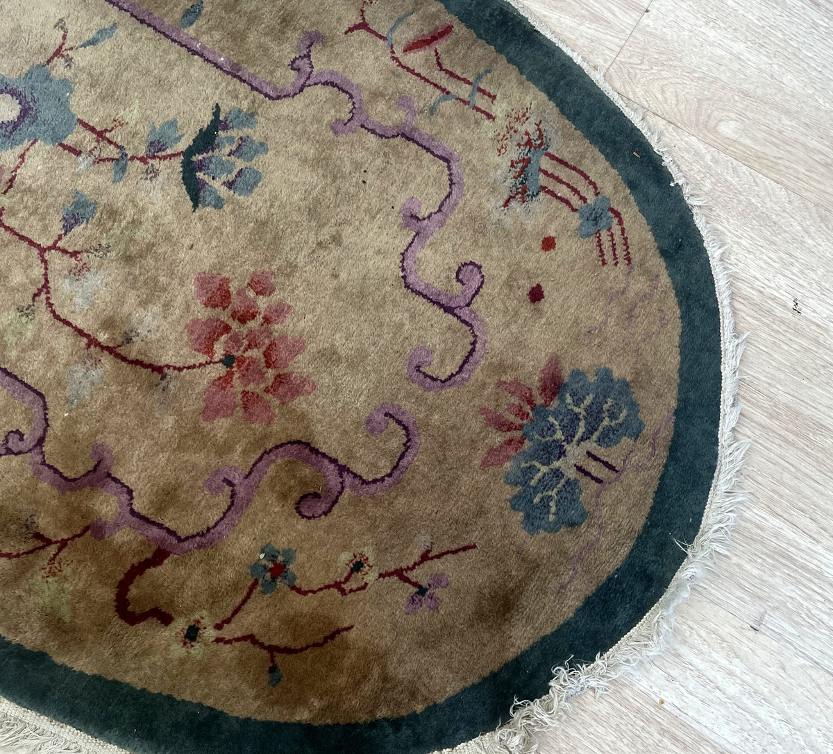 Upper oval end and age-related surface wear beside lilac scrollwork