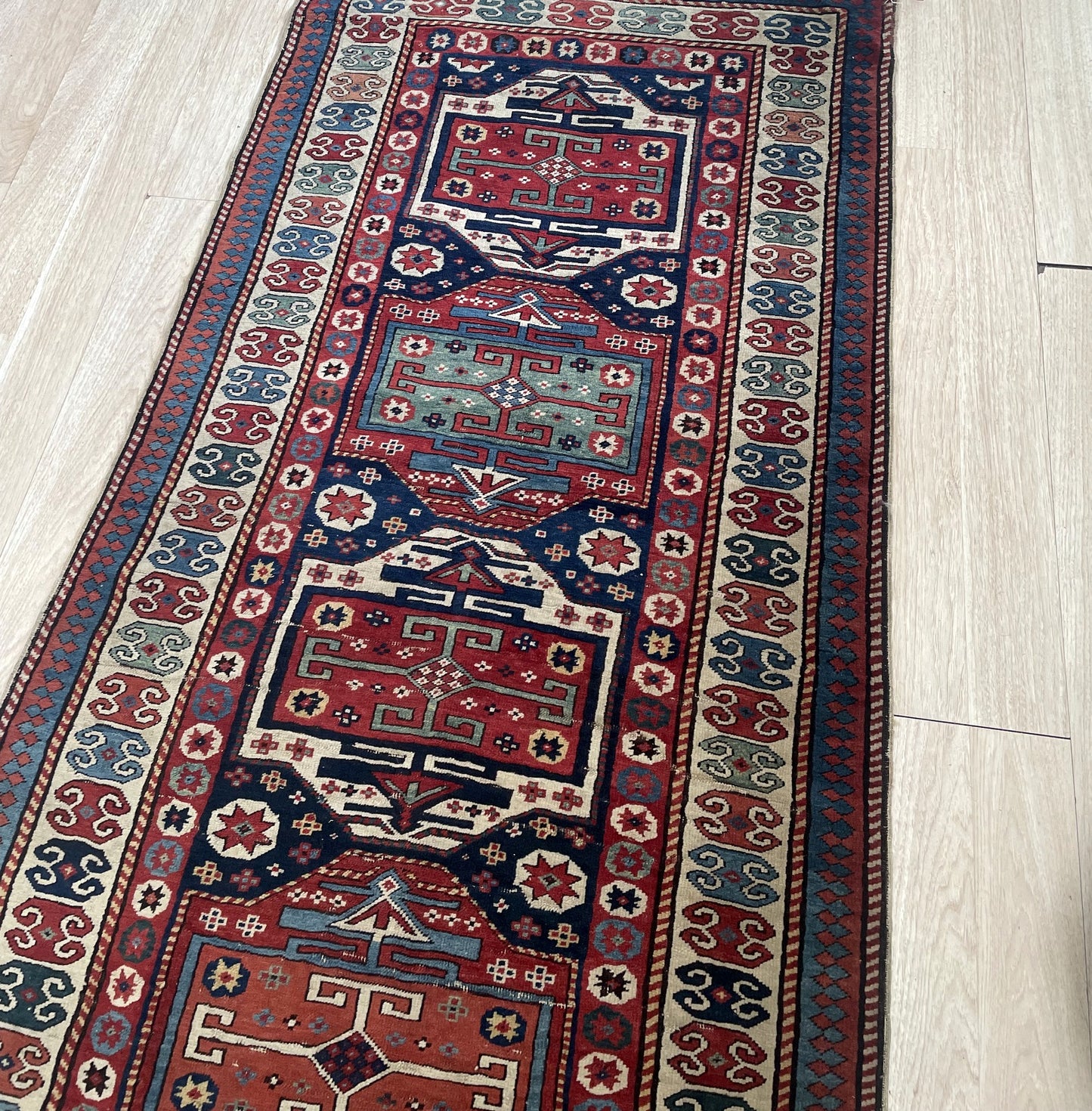 Close-up of bold primitive geometric designs and saturated natural dyes characteristic of Caucasus weaving