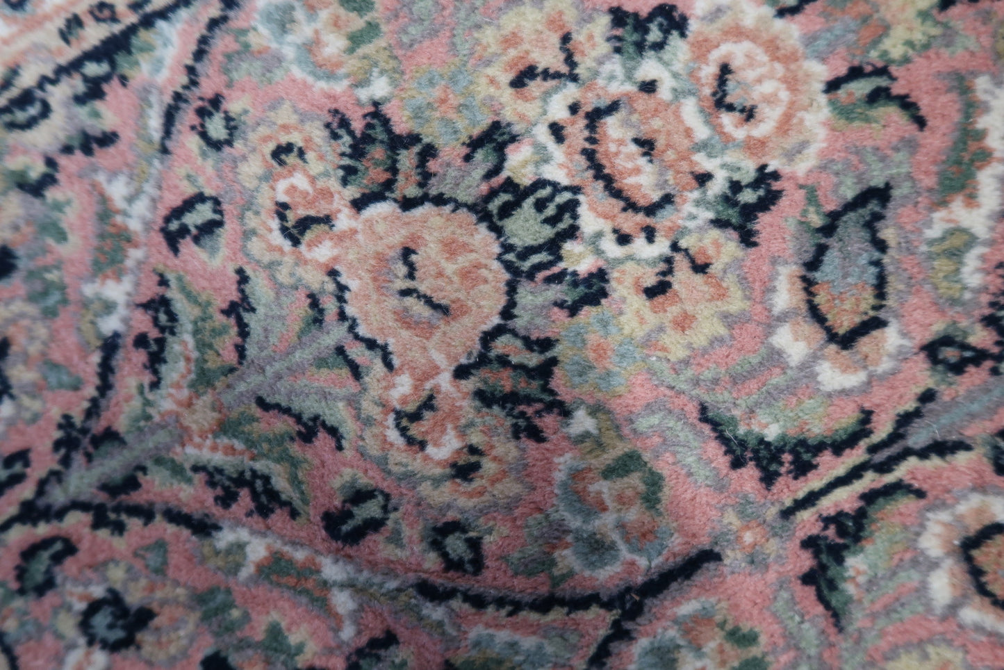 Detailed picture capturing the unique swampy green background and intricate details of the Persian Kerman rug.