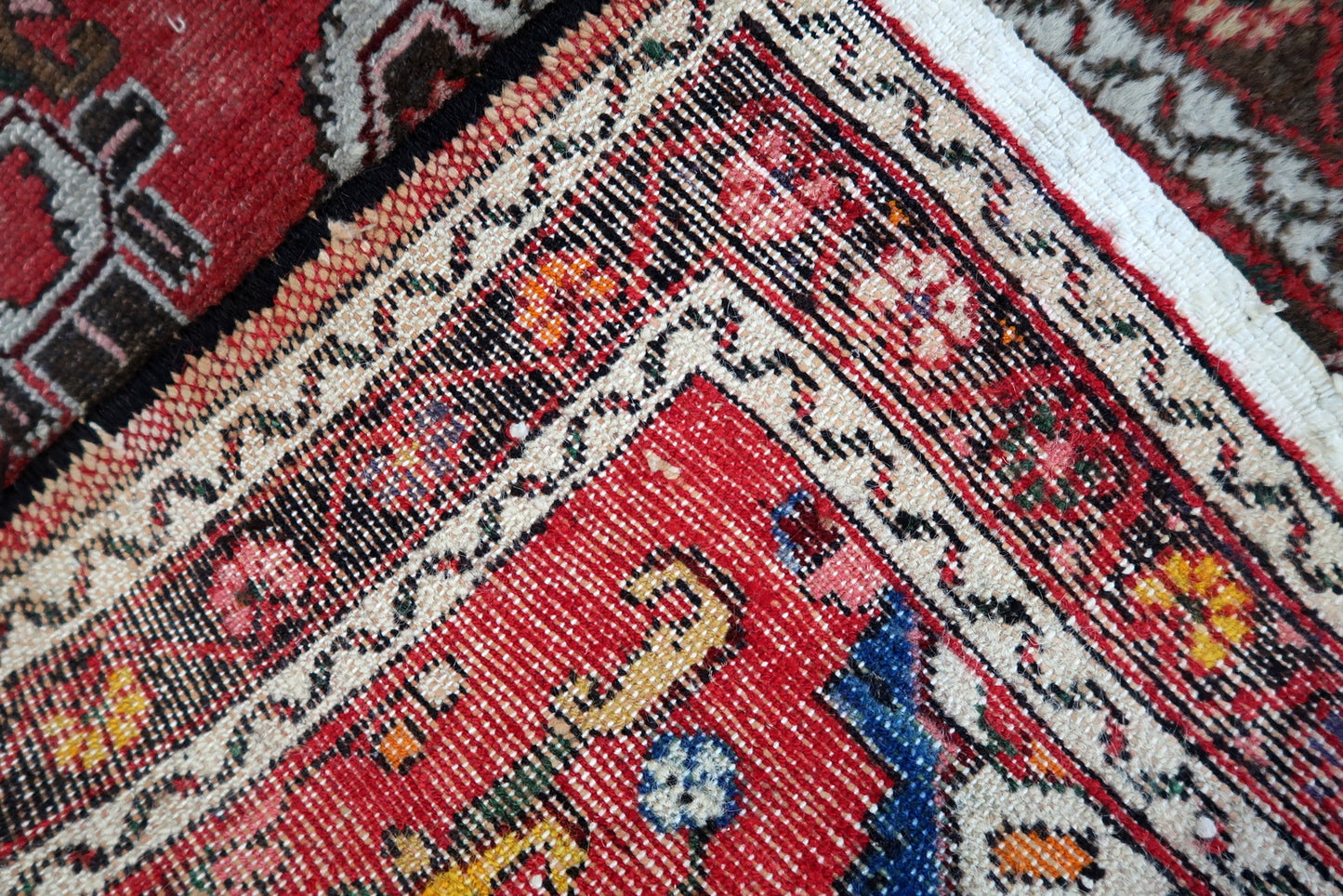 Cream and dark outline motifs on warm red runner