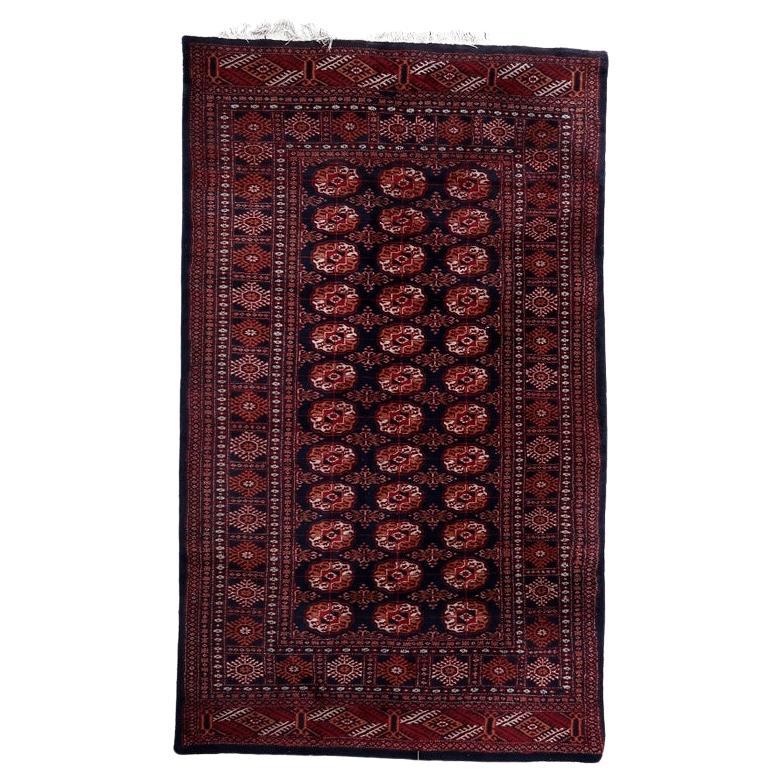 Handmade vintage Uzbek Bukhara wool rug with traditional tribal “gul” pattern