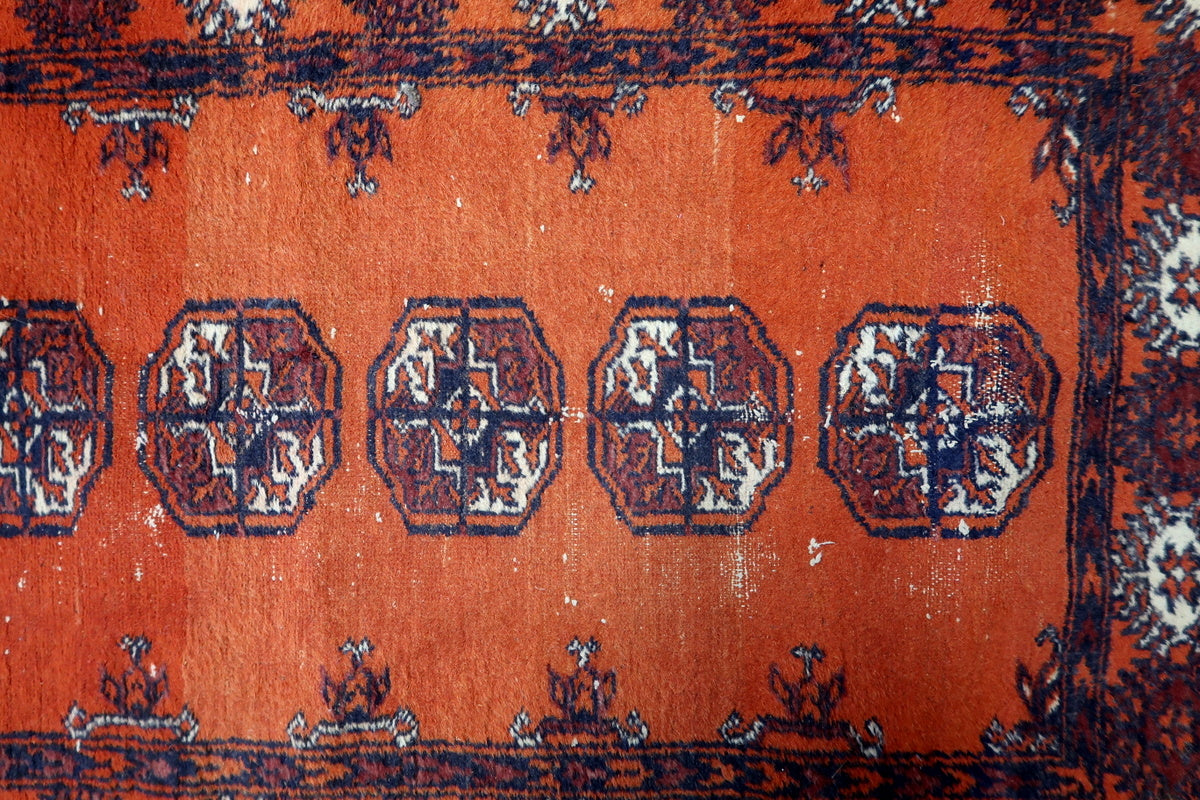 Detailed view of the intricate floral borders on the Uzbek wool rug