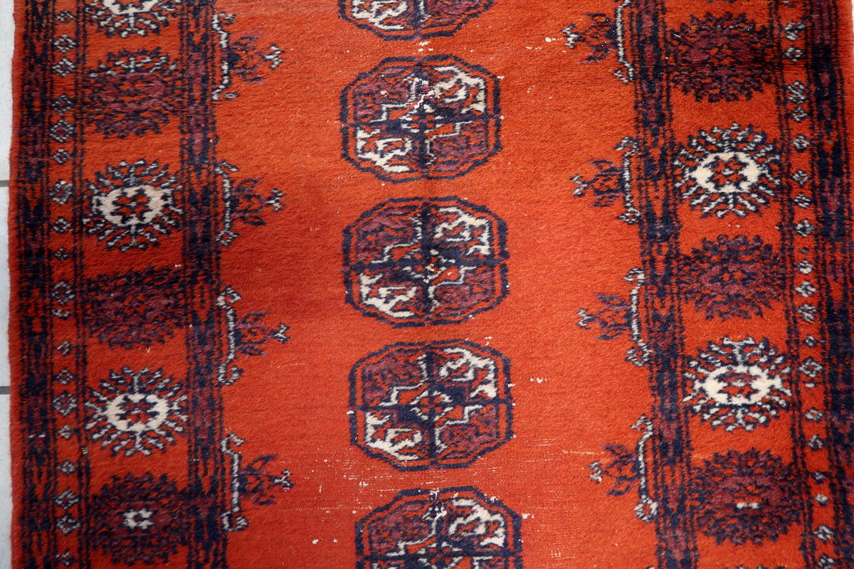 Rich red background with symmetrical blue and white patterns on the Uzbek carpet
