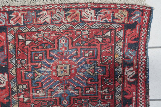 Close-up of the intricate floral and angular motifs in a vintage Karajeh rug