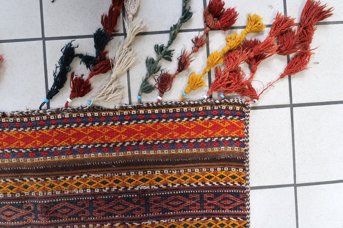 Antique wool Kilim rug folded to reveal its backside craftsmanship and weaving techniques