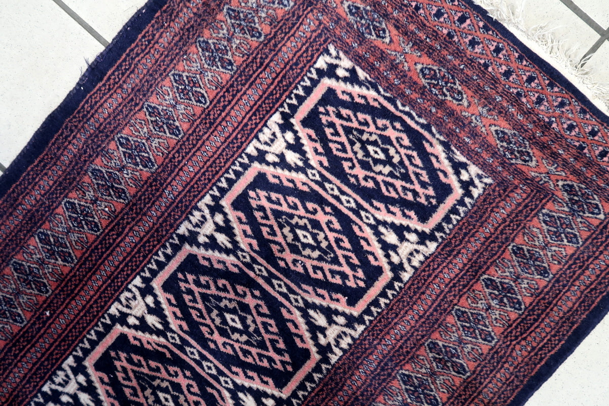 Decorative borders with symmetrical tribal designs on the vintage Uzbek carpet