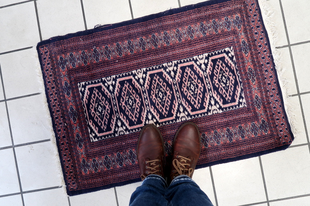 Rich color combination of deep blue, warm red, and ivory on the 1960s rug