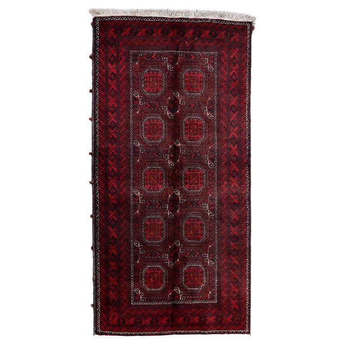 Close-up of the intricate geometric pattern on the handmade Afghan Baluch rug