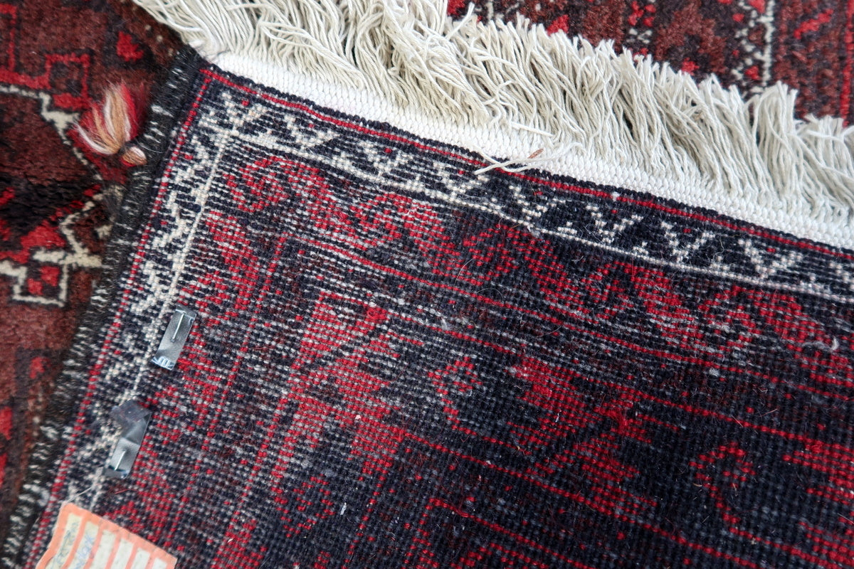 Rug folded neatly showing the underside and signs of handmade craftsmanship