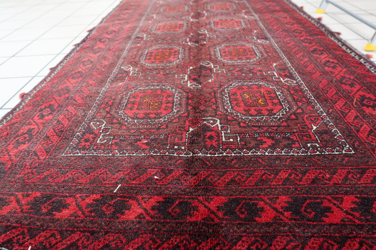 Natural vegetable dye colors on the vintage Baluch rug with detailed weave close-up