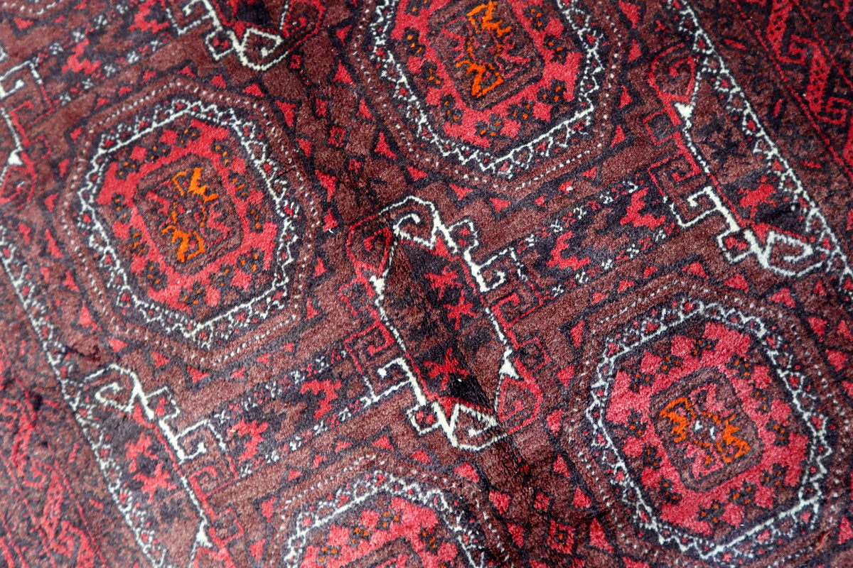 Close-up of the tribal octagonal motifs woven into the Afghan Baluch rug