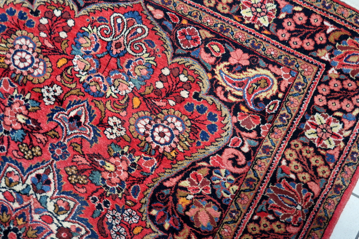 Close-up of the rug’s deep reds, navy blues, and golden tones
