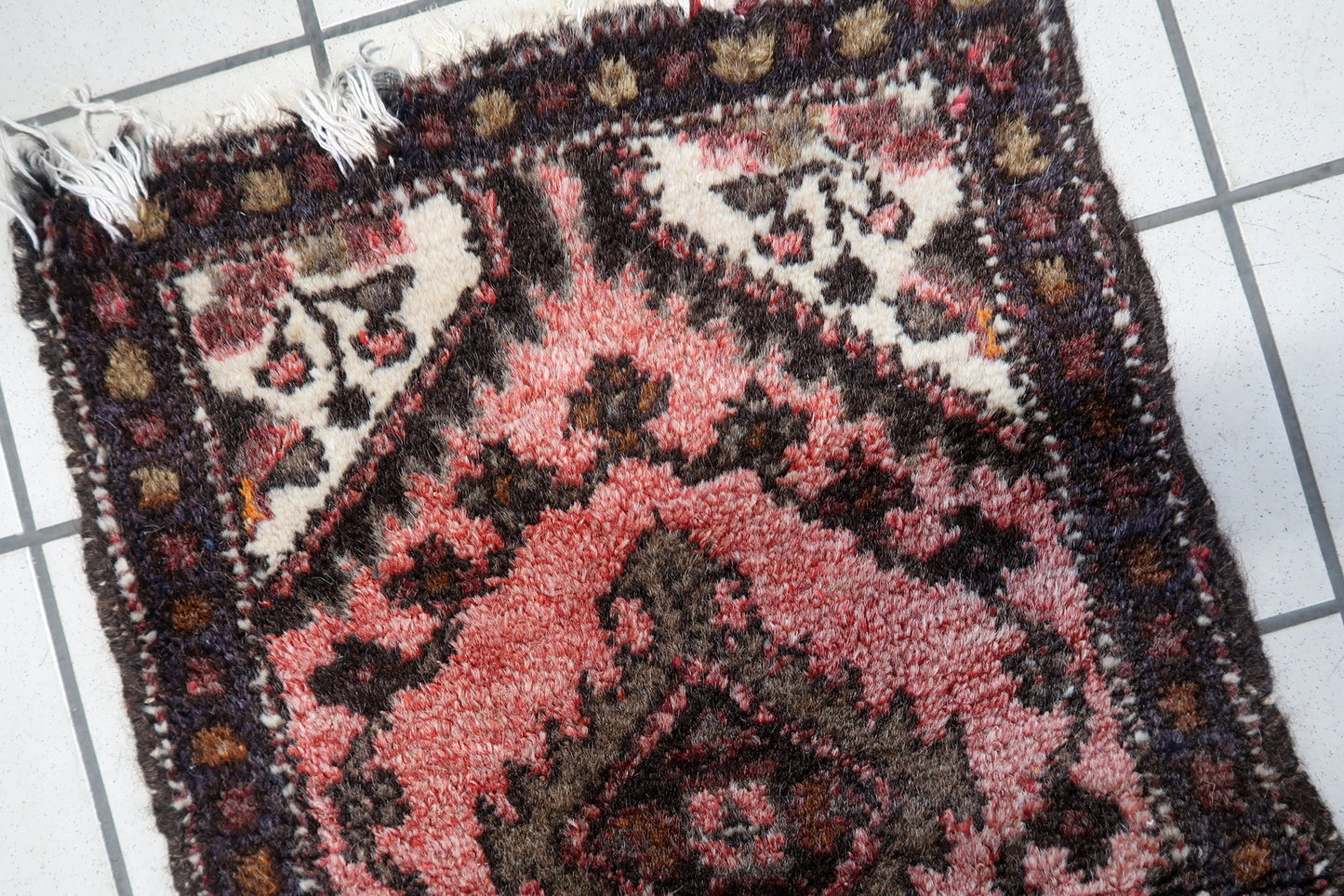 Close-up of intricate Uzbek wool rug patterns in warm earthy tones