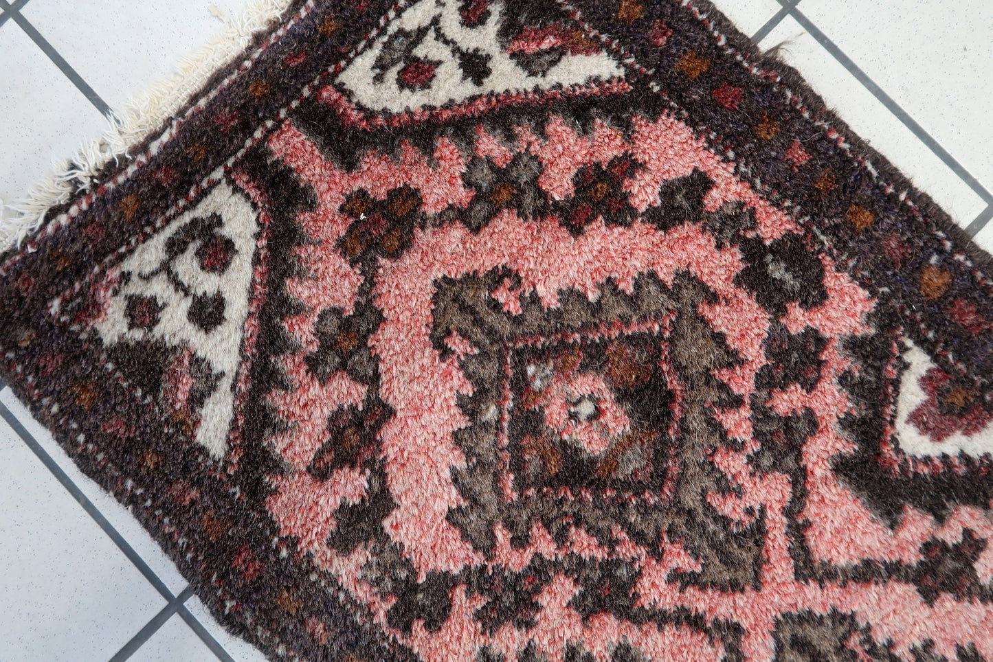 Side view of long and narrow Bukhara runner rug in terracotta and brown