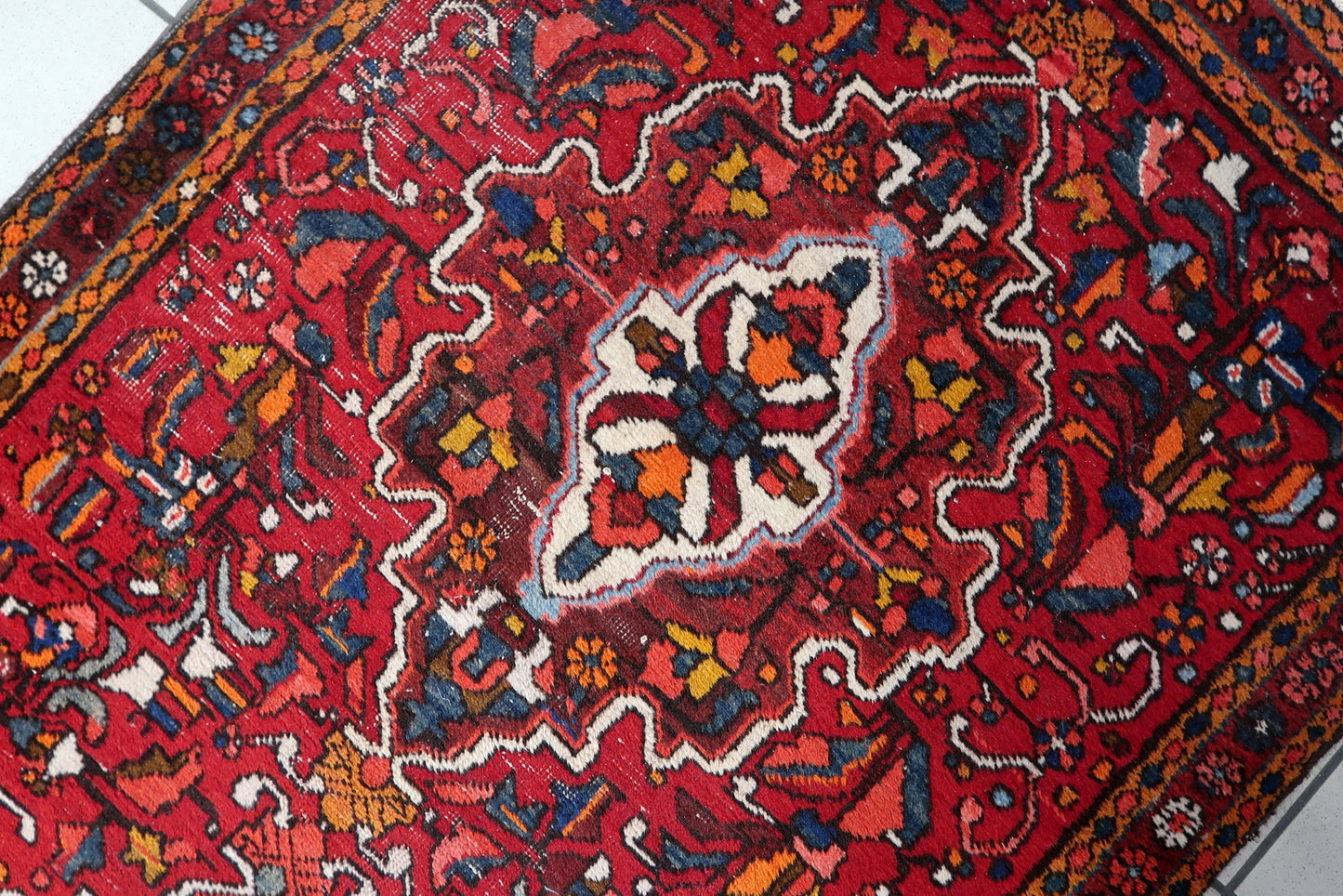 Long Persian Karajeh runner rug with rich red, deep blue, and ivory tones
