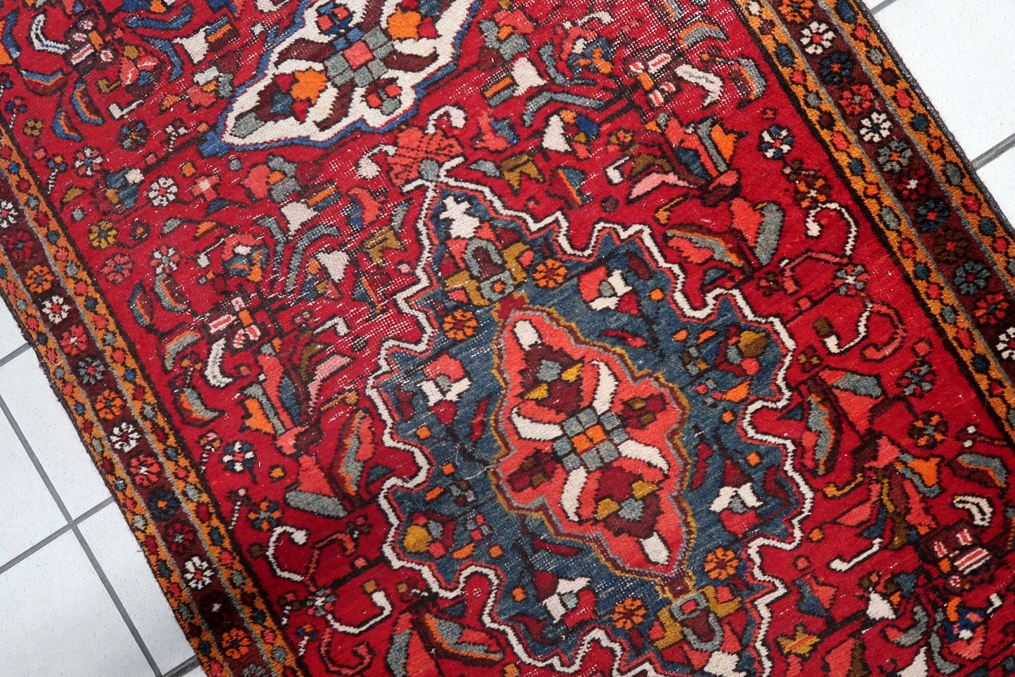 Side view of a vintage Persian wool runner rug with tribal motifs