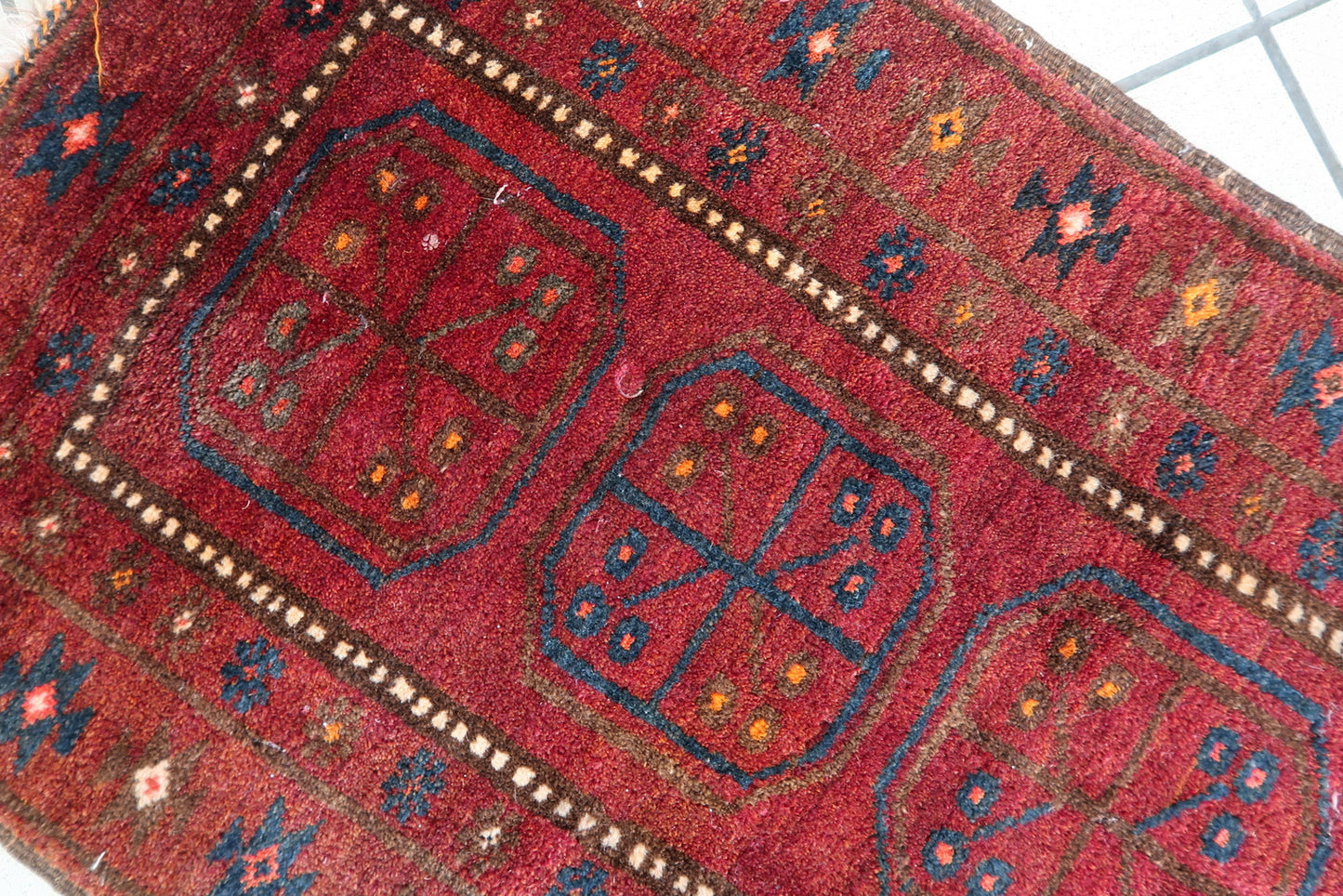 Textured wool pile of a vintage Afghan handwoven rug