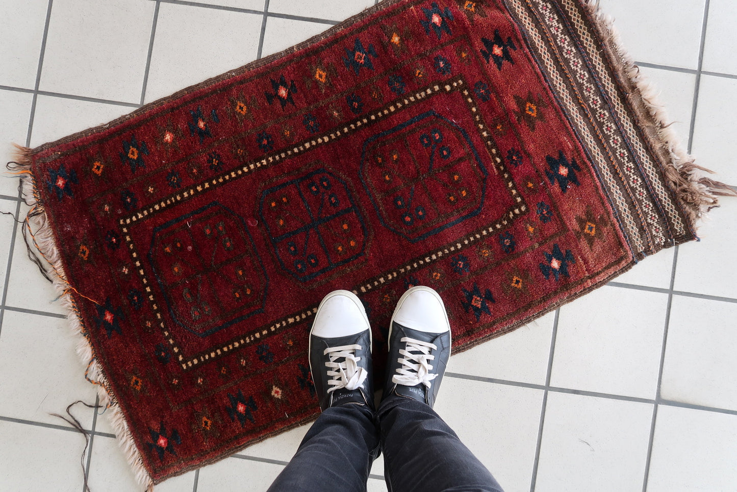 Decorative small wool rug with intricate Persian-inspired patterns