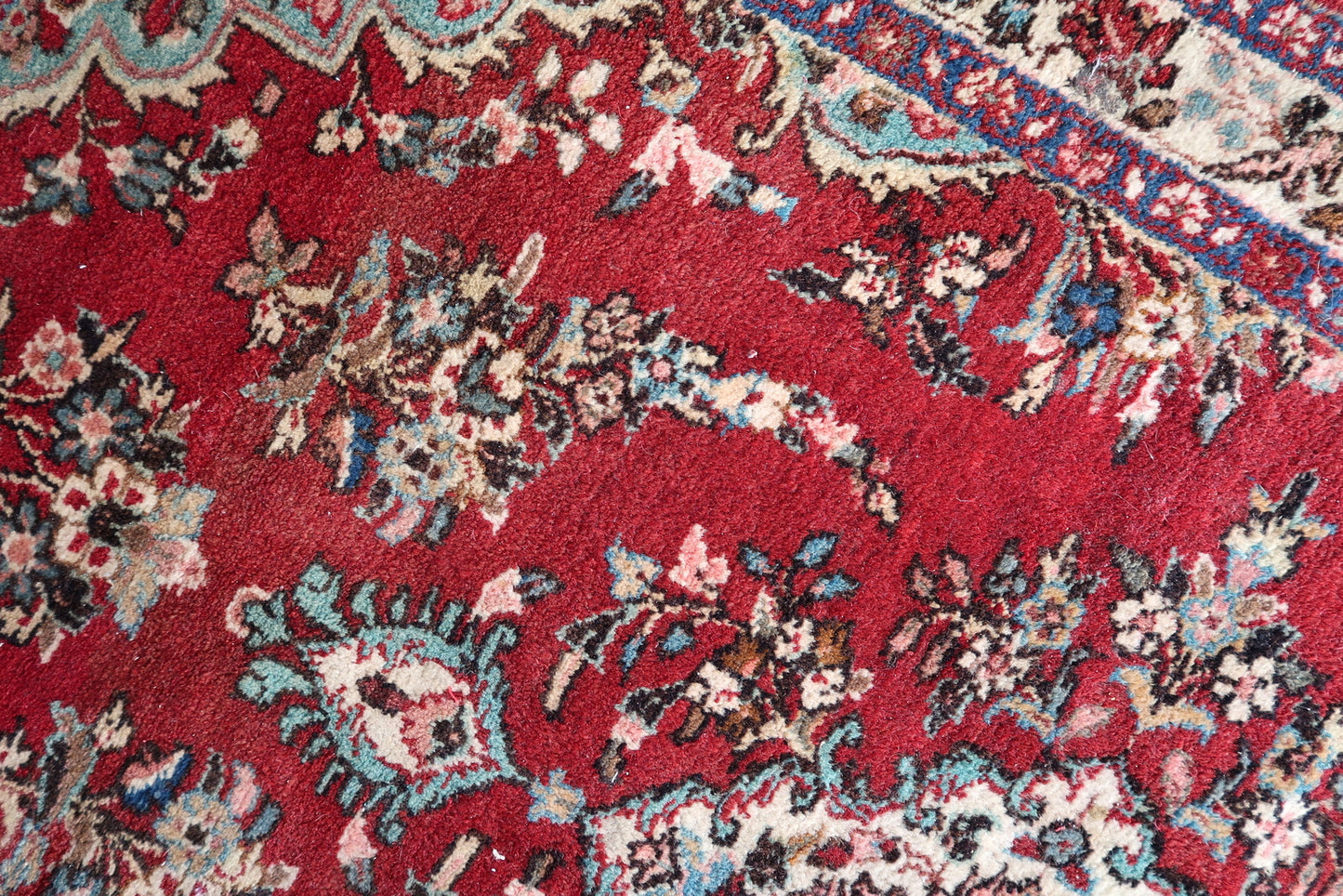 Geometric floral rug in dark blue and rose colors