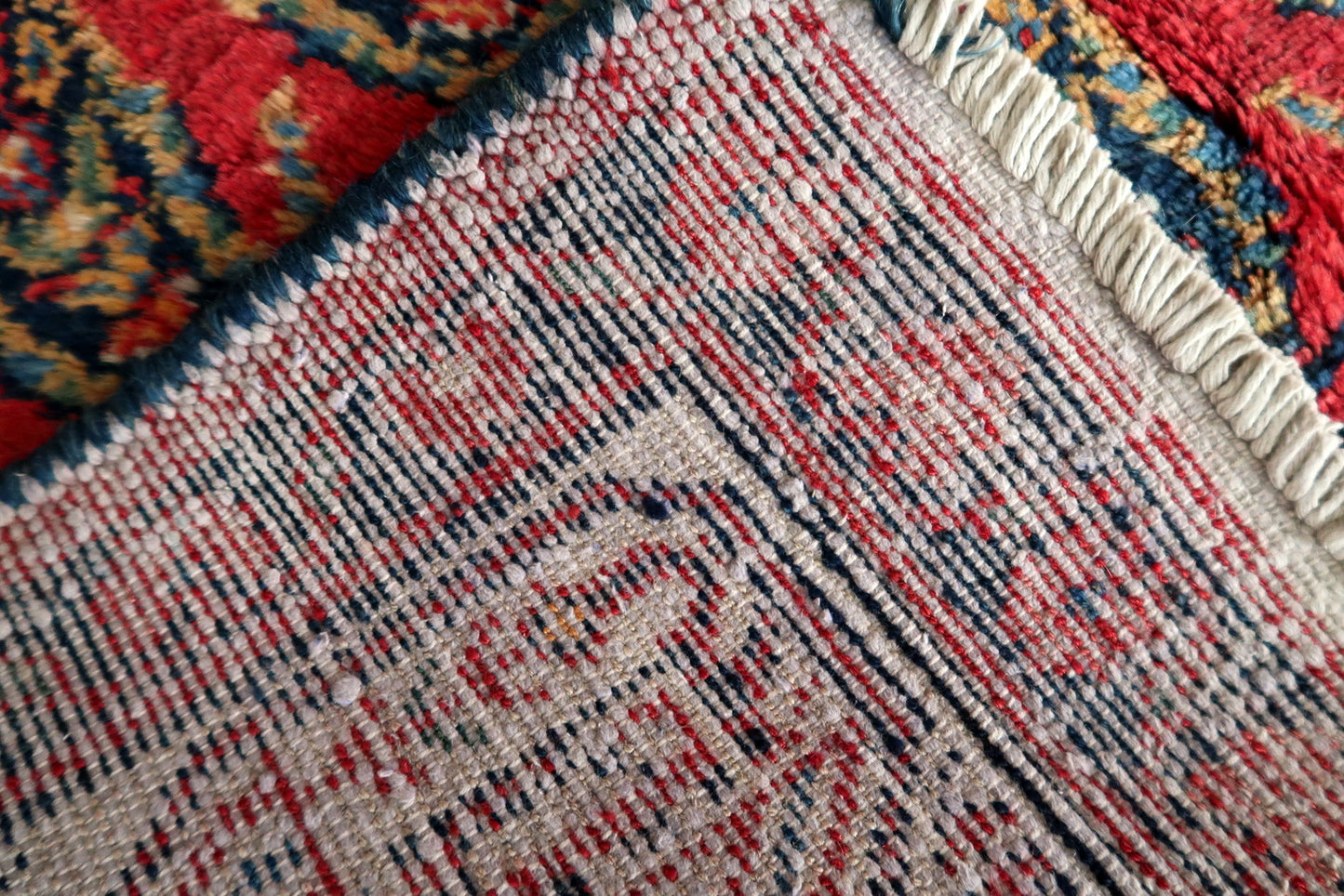 Shot of the rug's edge and fringe, demonstrating its original condition.