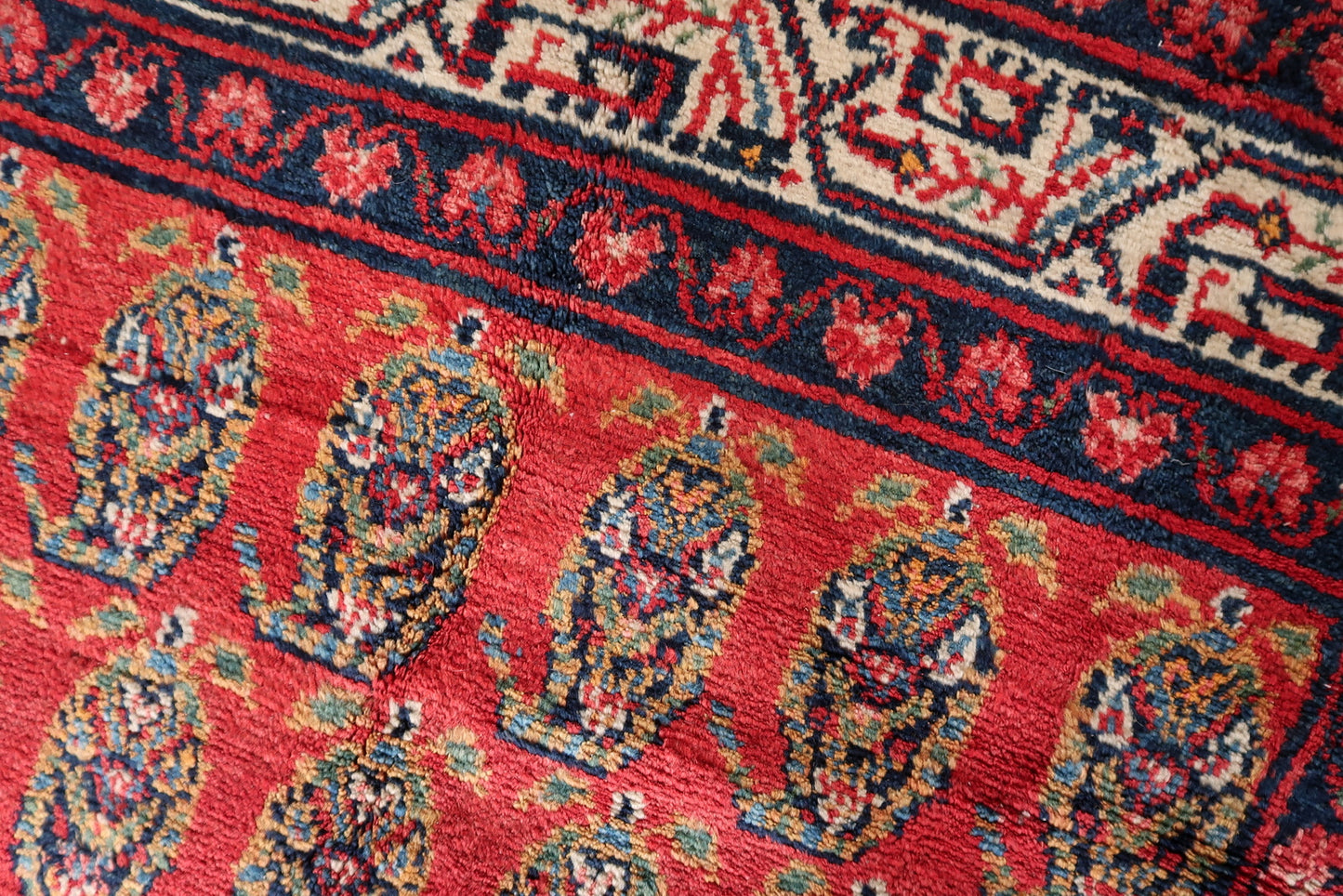 Texture shot showing the dense, plush wool pile of the handmade Hamadan carpet.