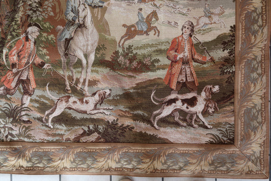 Close-up of huntsmen in red coats on horseback in a forest.