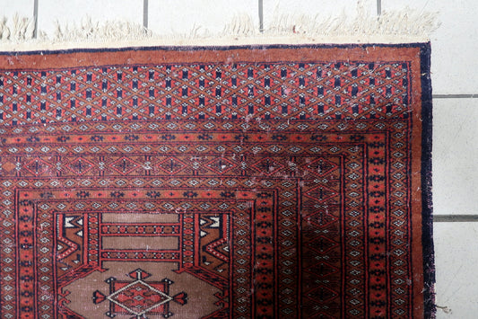 Close-up of a single detailed gul motif in navy blue and burgundy.