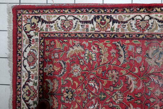 Close-up of floral and botanical motifs on rich red background