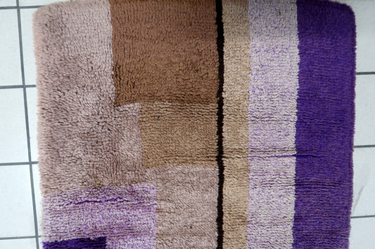 Close-up detail of the abstract, block-like geometric forms in purple and brown.