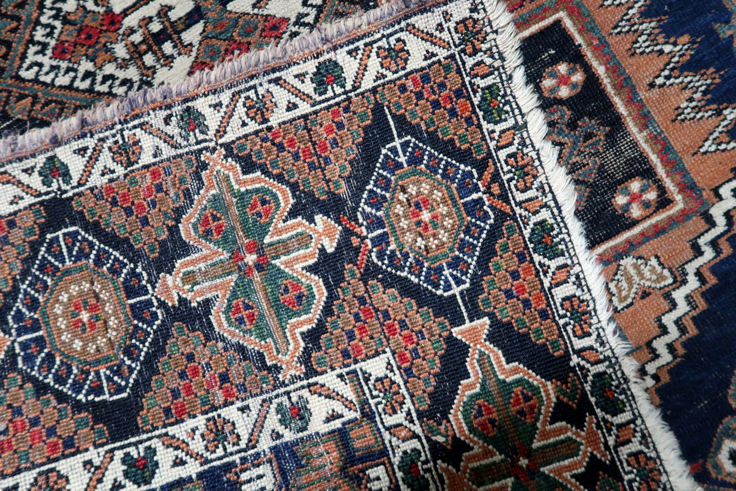 A 3.8 x 4.6 foot antique Persian rug with warm rust and navy tones, perfectly sized as a characterful accent for an entryway or reading corner.