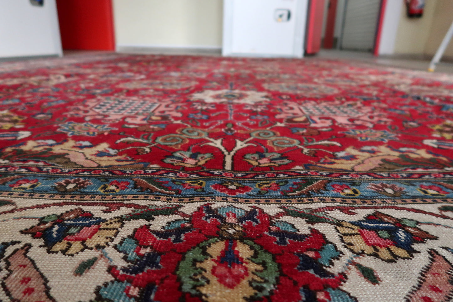 Full view of a circa 1920s Persian Tabriz rug with an allover Shah Abbasi floral scroll design covering the entire field, demonstrating the master cartoonist's skill and highly skilled weaving team required to execute this pattern at room scale without visual repetition.