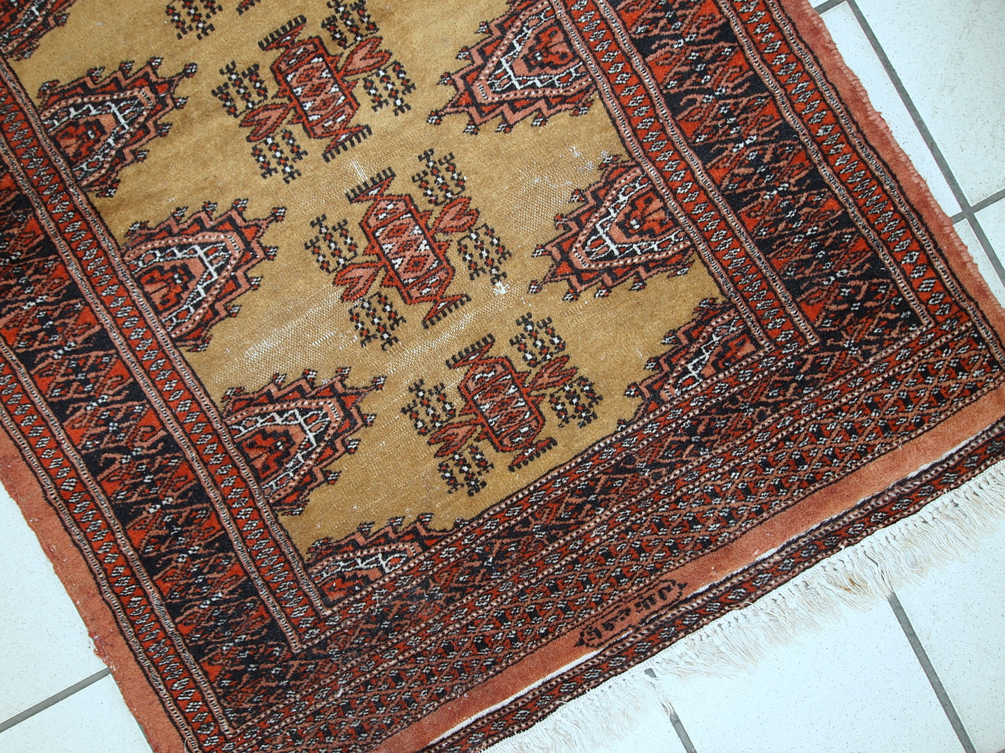 Detailed shot of the wool texture and colors in the handmade vintage Bukhara rug.