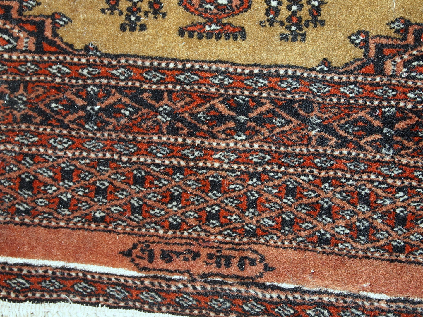 Vibrant geometric patterns on the vintage Uzbek Bukhara rug from the 1960s.