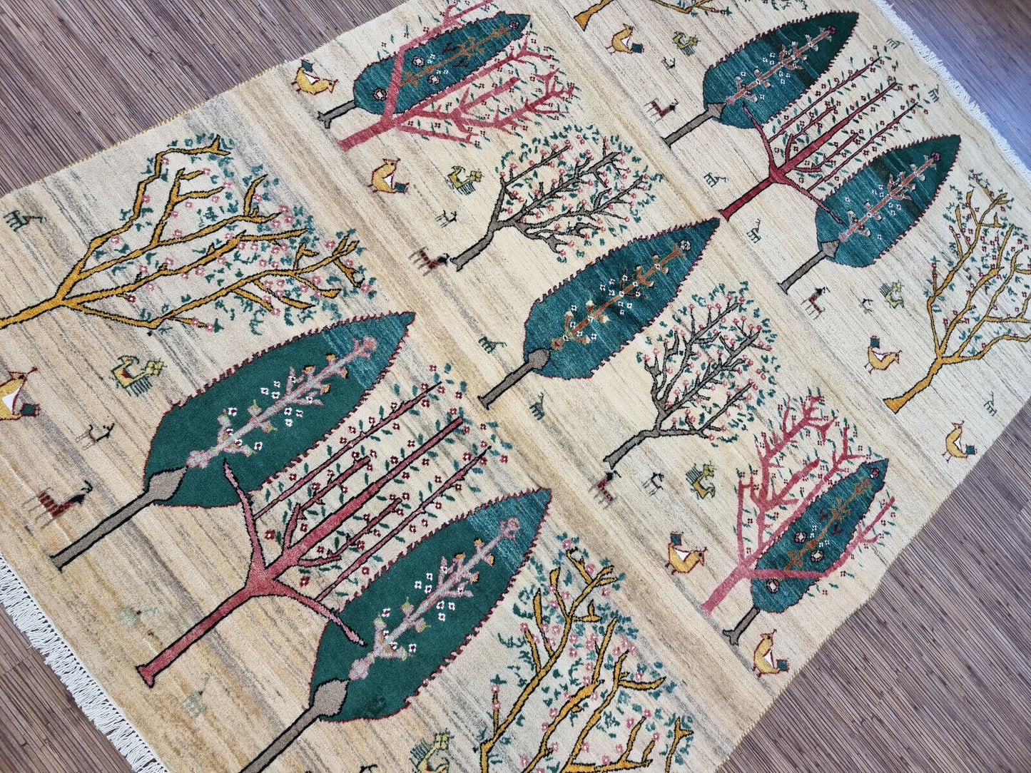 Detailed view of a bird perched on a tree branch on the Gabbeh rug
