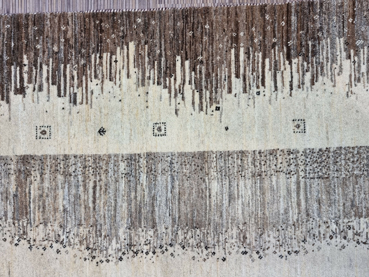 Subtle beige central field of the rug with decorative accents
