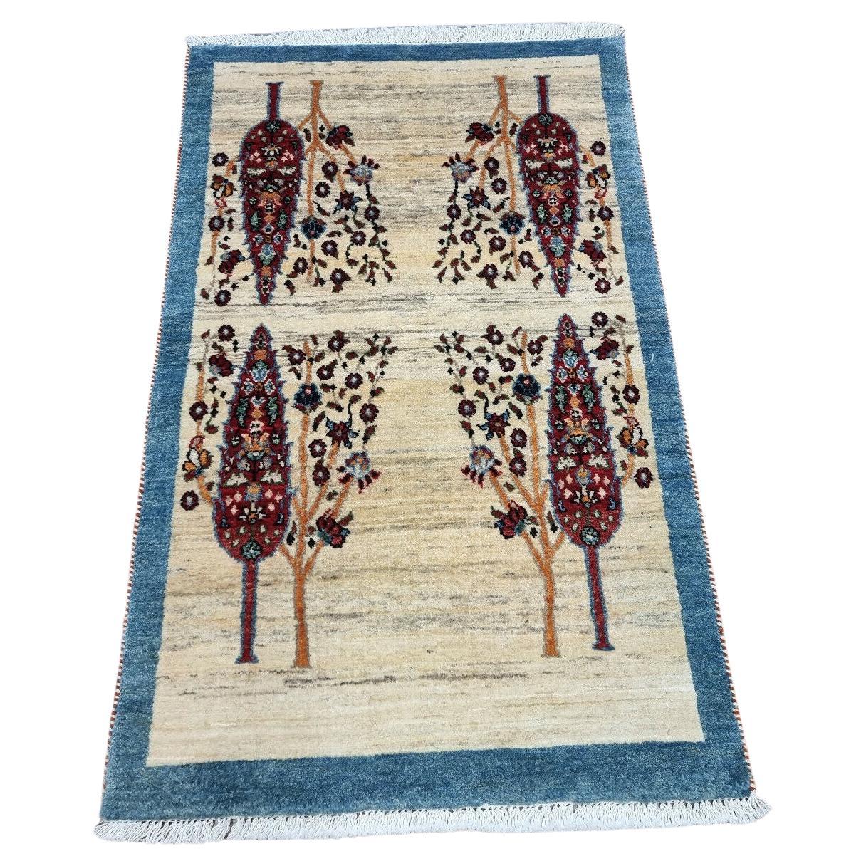 Close-up of hand-knotted Persian Gabbeh rug with tree-inspired motif