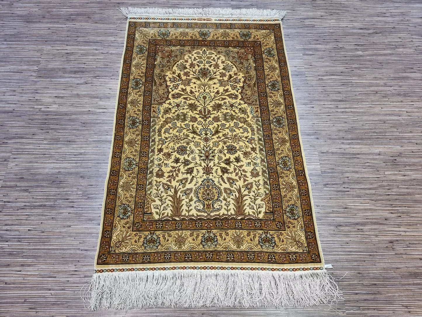 Detailed view of the medallion centerpiece on the Hereke prayer rug