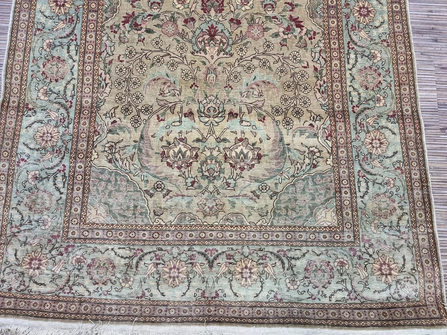 Close-up of the medallion centerpiece on a Hereke hand-knotted rug