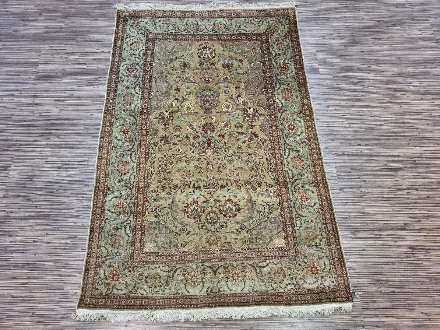 Full view of the rectangular Hereke silk rug, professionally preserved