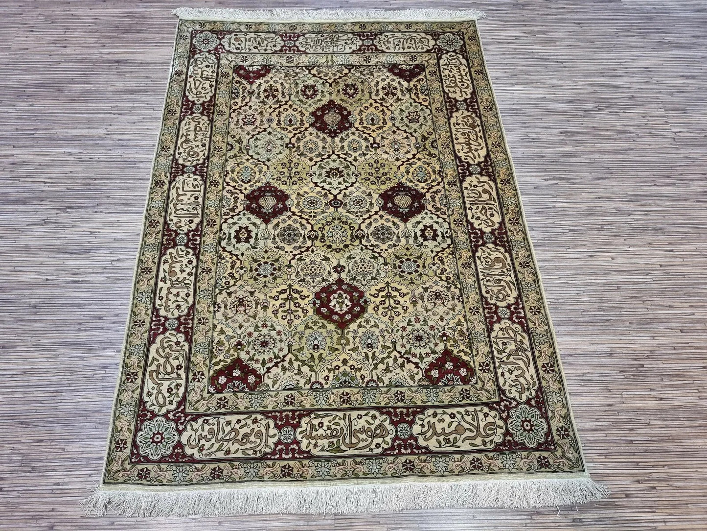 Calligraphic border motifs adding sophistication to the Hereke rug design