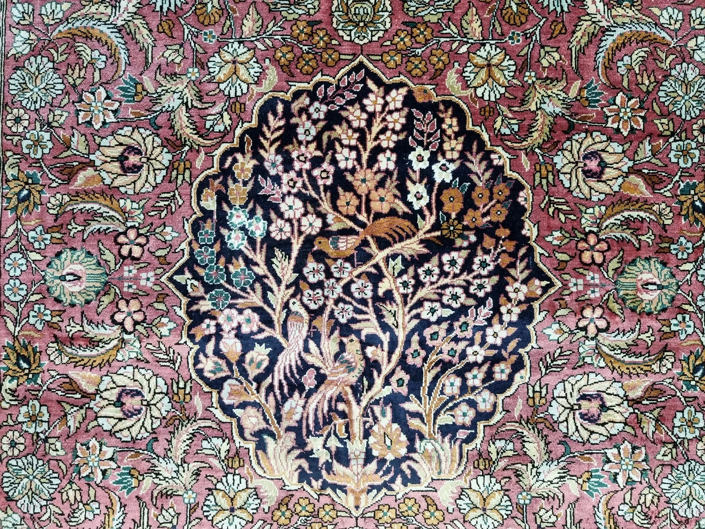 Handmade Chinese silk rug hanging on a wall for display.