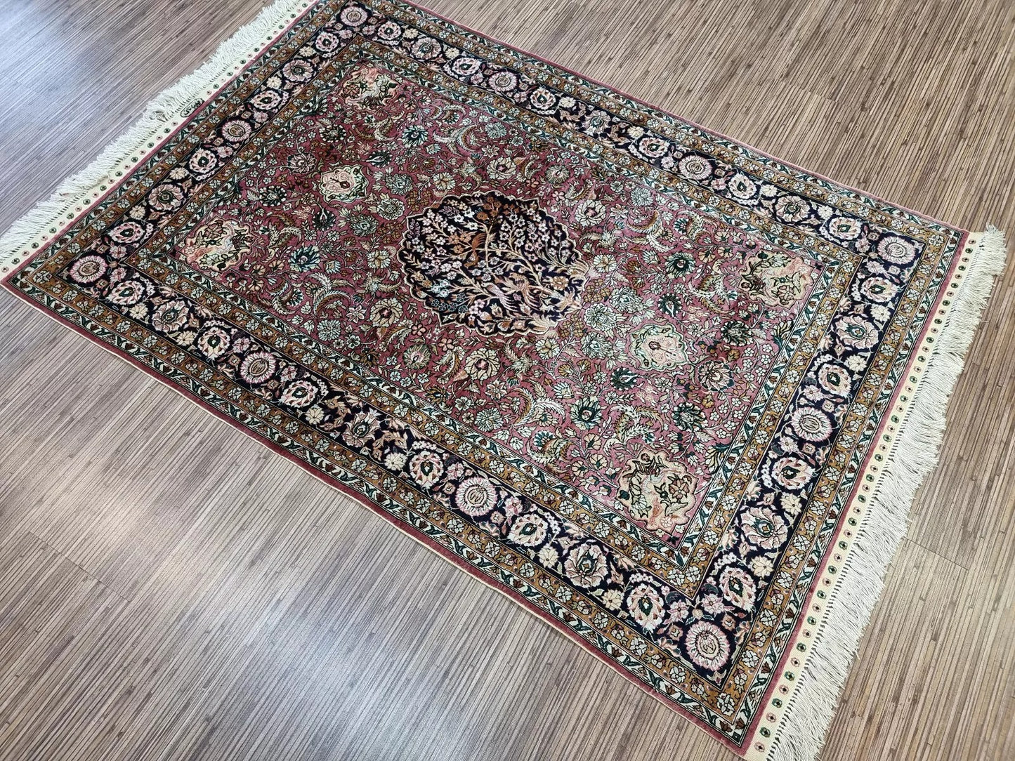 Detailed view of fringe on the edges of the Qum silk rug.