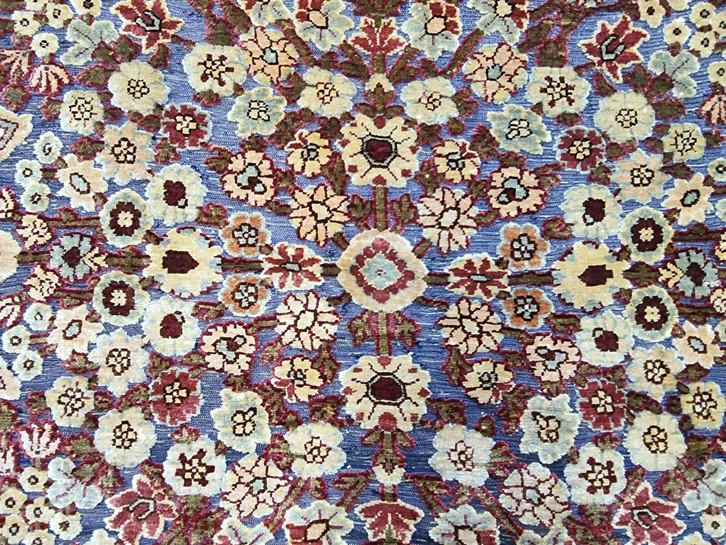 Close-up of hand-knotted silk details on a vintage Hereke rug.