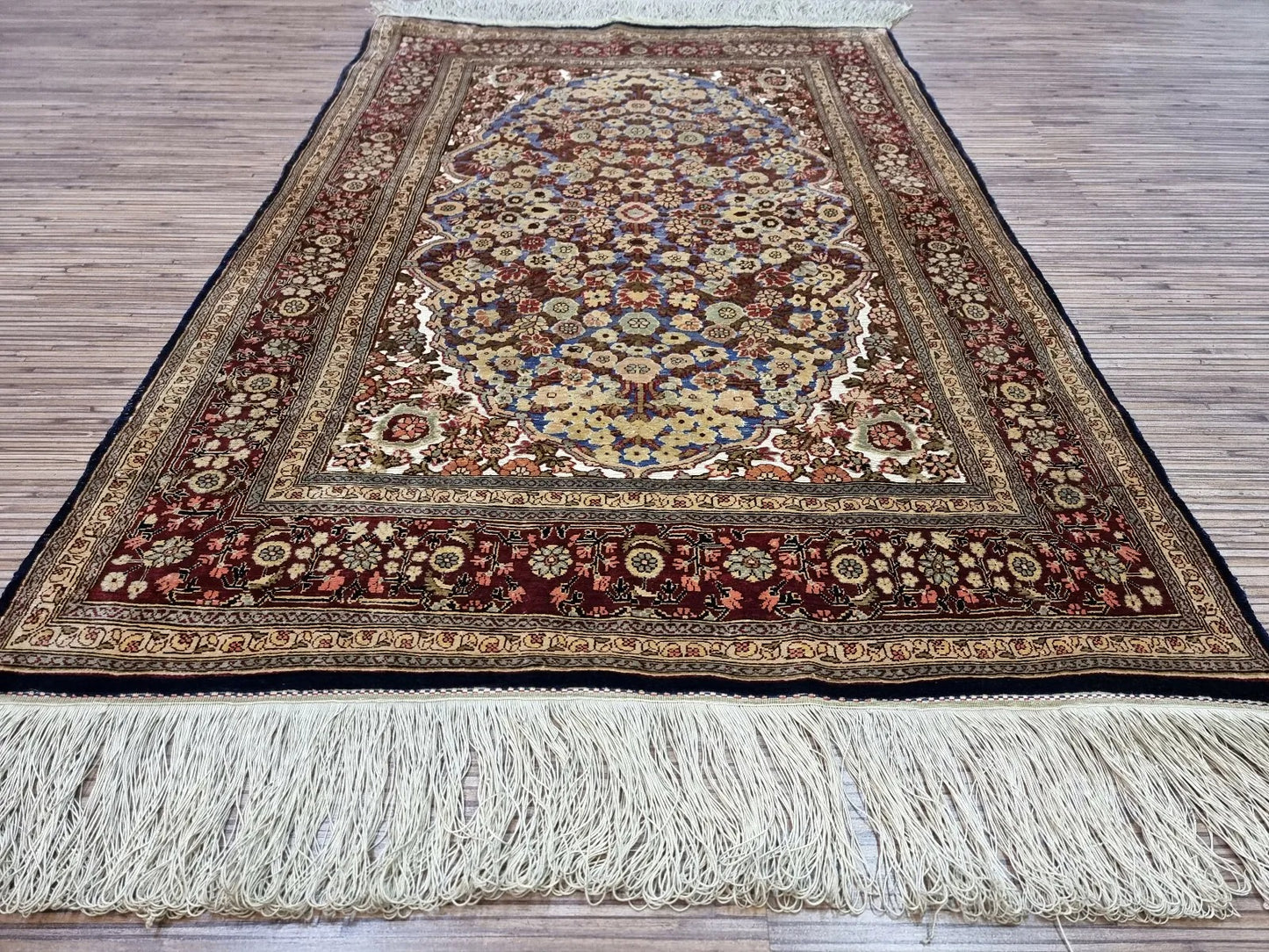 Multicolor silk rug with a balance of floral and geometric patterns.