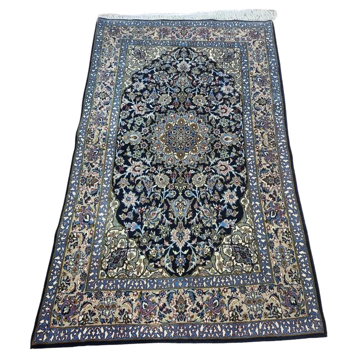 Handmade vintage Persian Isfahan rug with intricate floral motifs and a rich blue palette