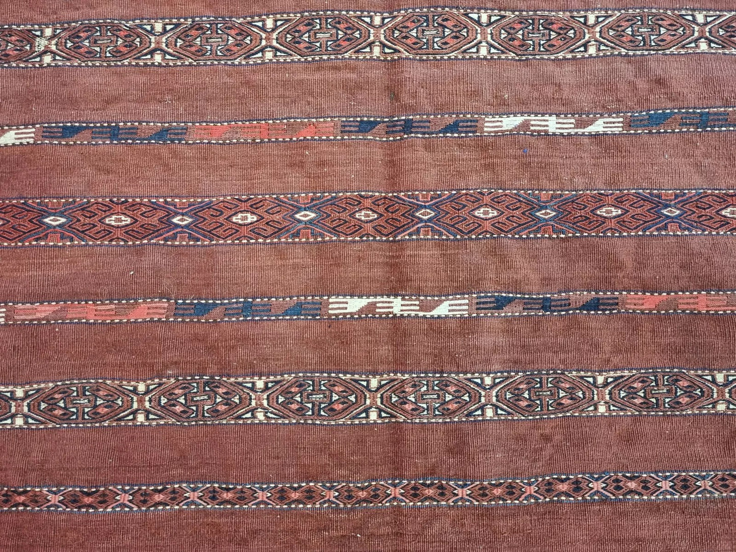 Flatwoven antique wool bag with deep red, brown, and ivory hues