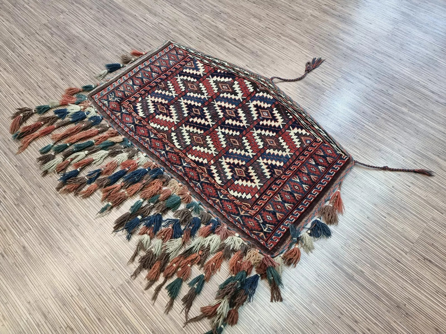 Antique Turkmen rug displayed in a living room setting