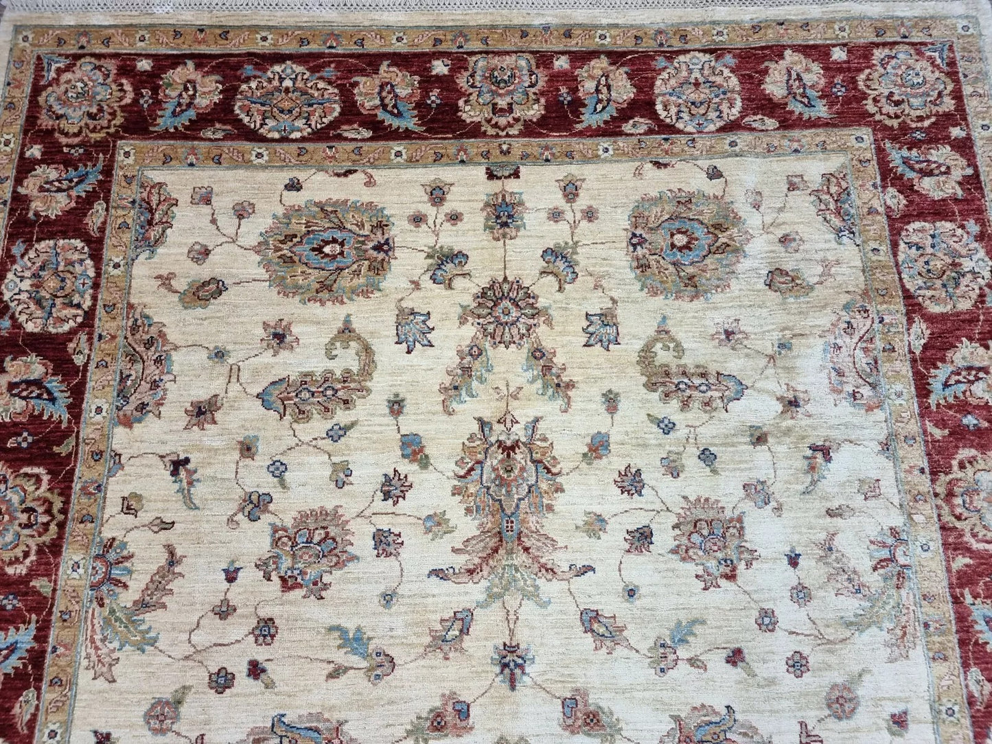 Traditional Afghan wool rug with floral layout