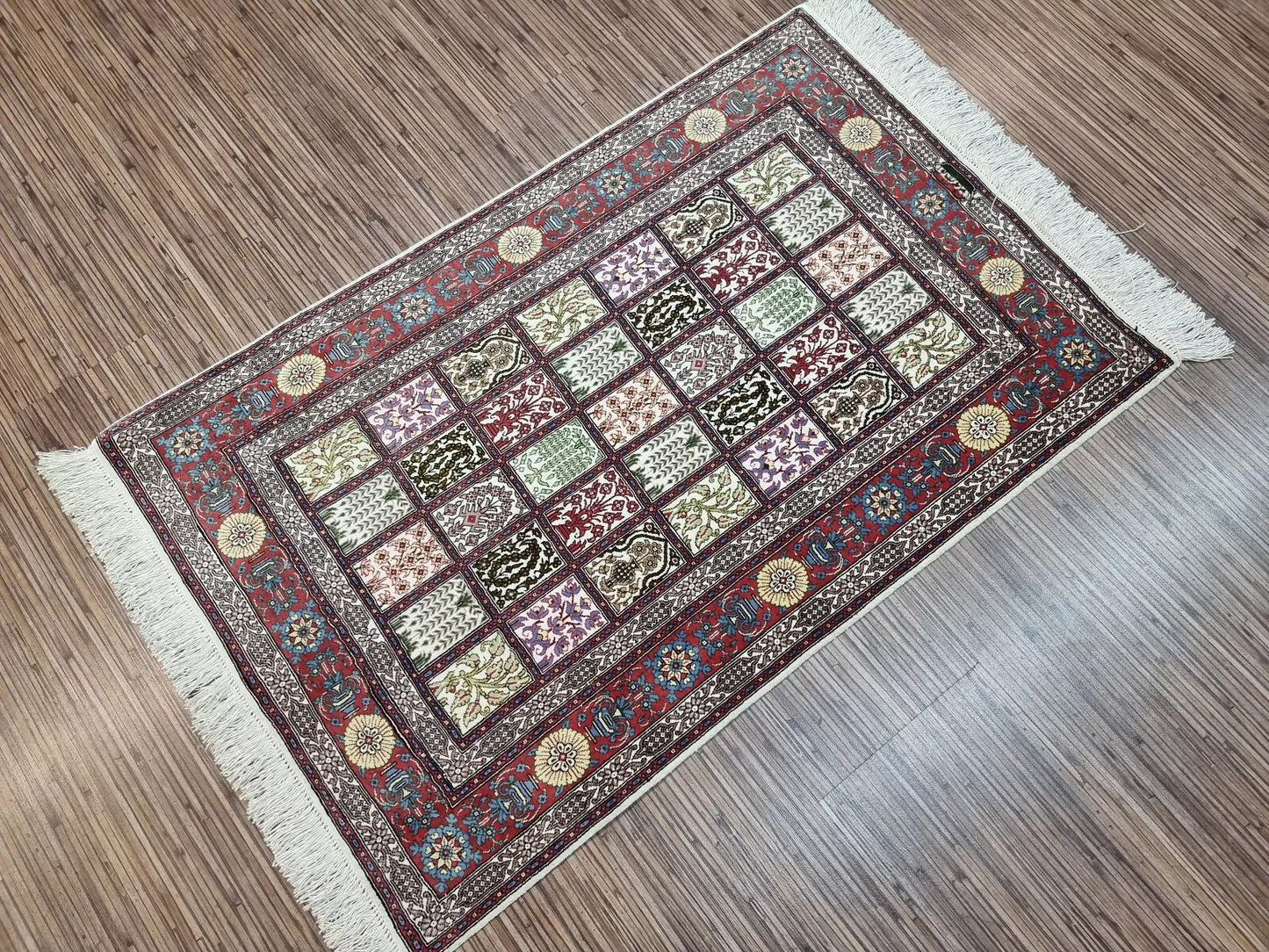 Intricate floral and vine motifs on Qum rug