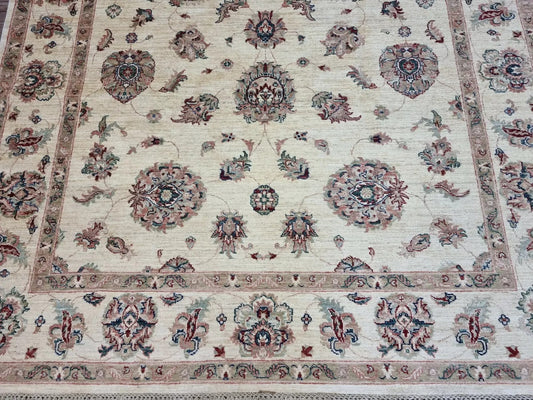 Close-up detail of a large floral medallion in soft brown and ivory wool.